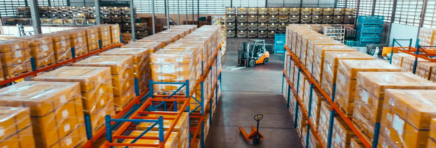 Forklift moving pallets between rows of racked storage in a Jiva Consultings warehouse
